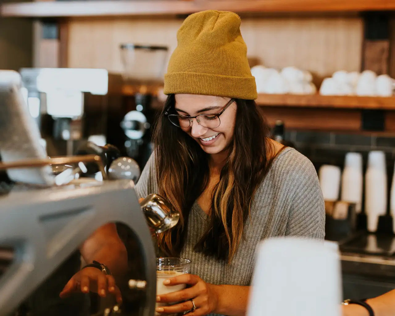 Barista making coffee at coffeeshop wearing glasses from The Optical. Co