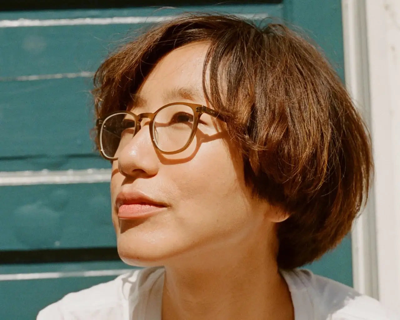 Person wearing GLCO eyeglasses with Trivex lenses from The Optical. Co