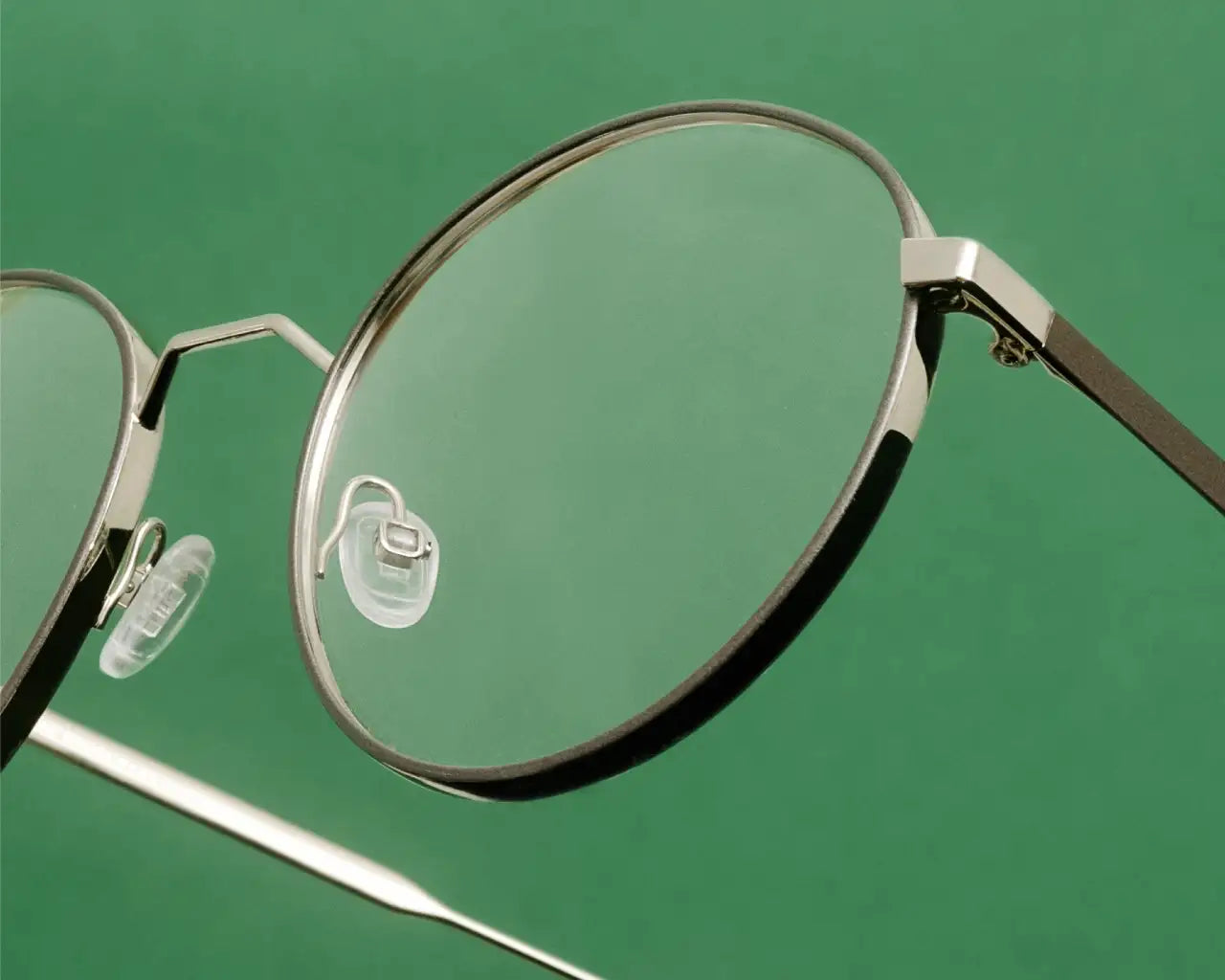 Andy Wolf metal round luxury eyeglasses on green background