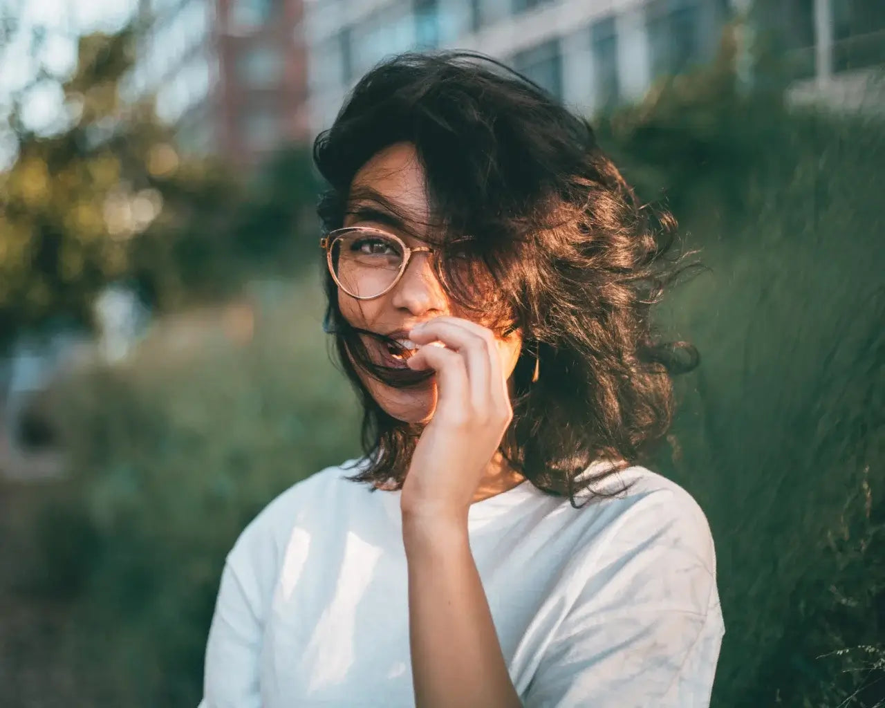 Woman wearing The Optical. Co rose gold eyeglasses on windy day outside