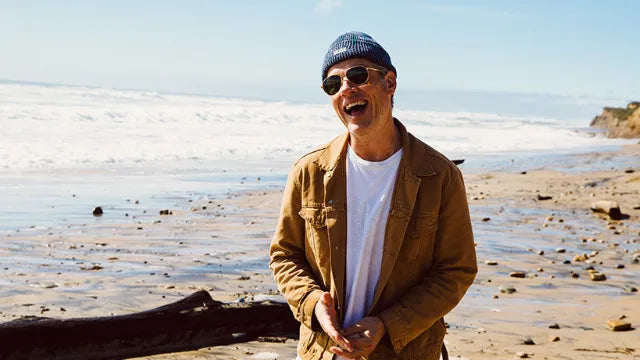 Happy man on beach wearing SALT luxury polarized metal sunglasses from The Optical. Co
