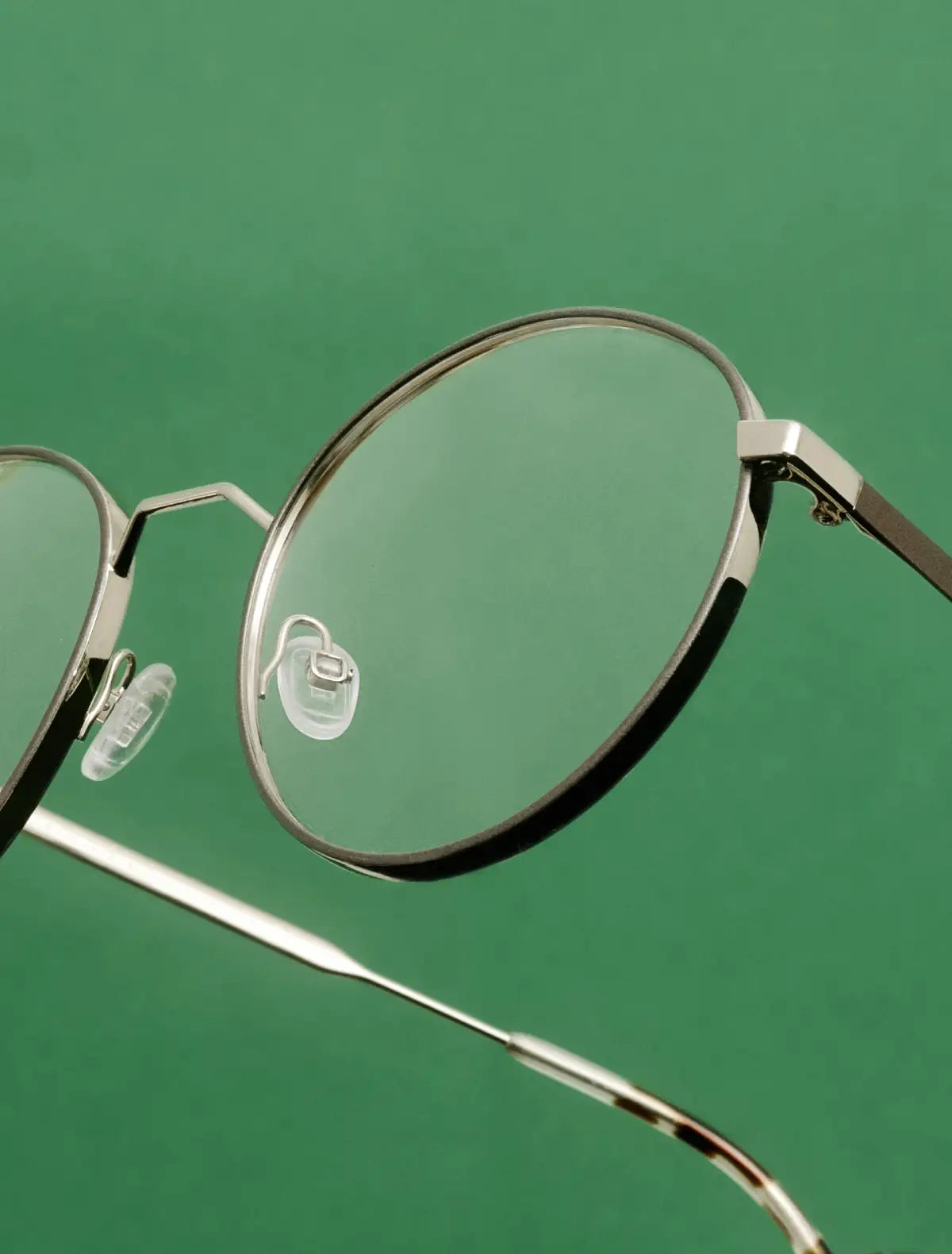 Andy Wolf metal eyeglasses on green background