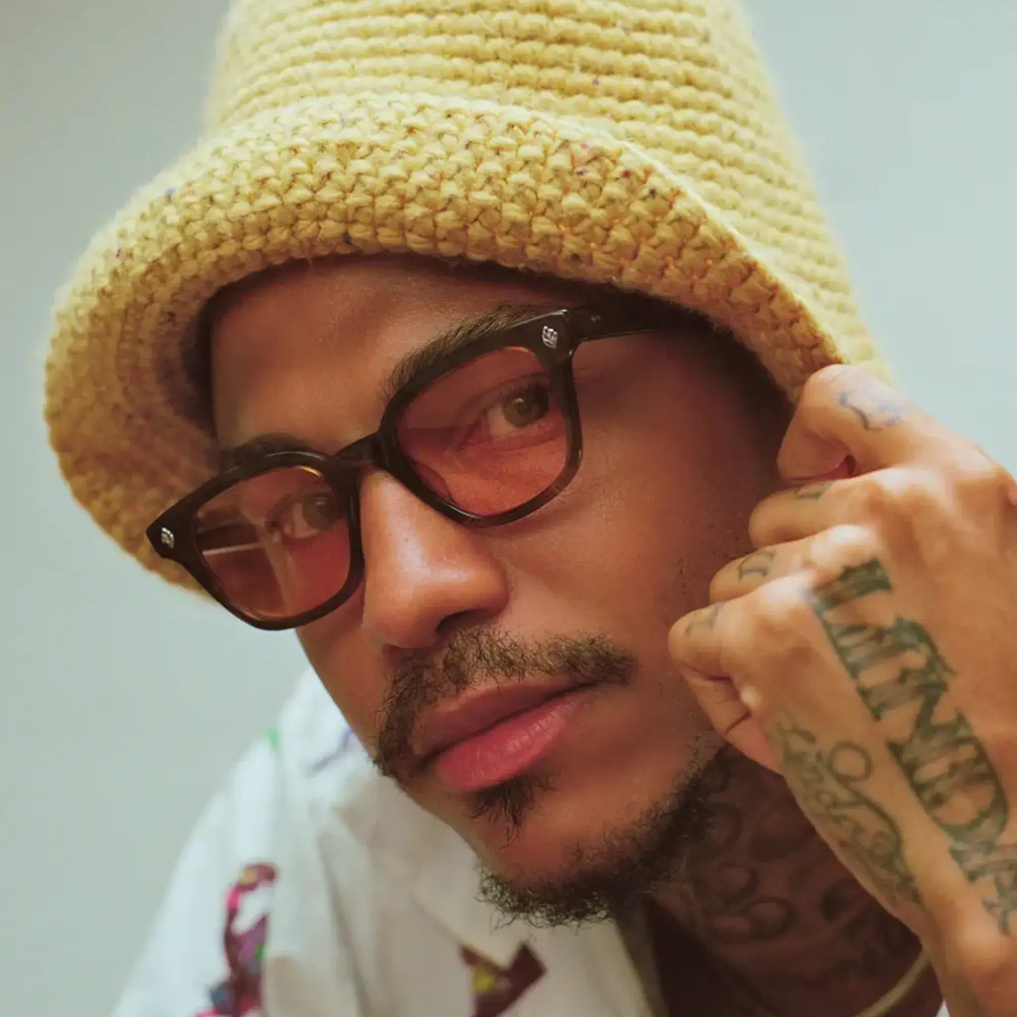 Model wearing yellow hat and GLCO Naples eyeglasses with custom red tinted eyeglass lenses