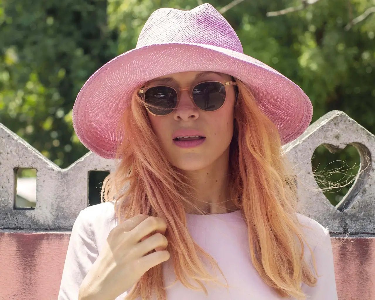 Woman in large pink hat wearing Garrett Leight sunglasses from The Optical Co