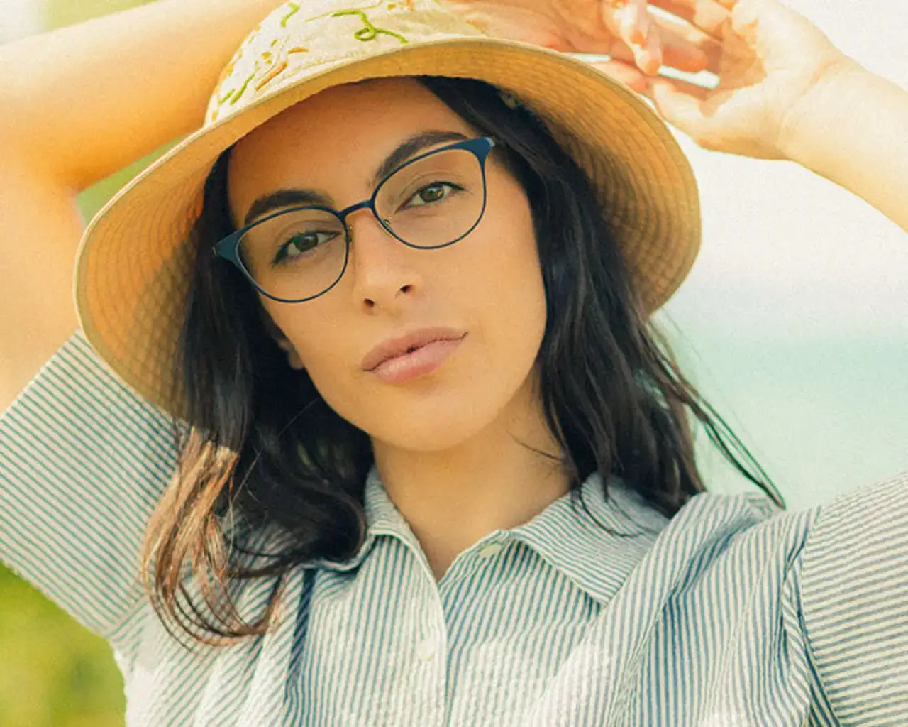 Woman in hat on sunny days wearing SALT metal eyeglasses from The Optical. Co