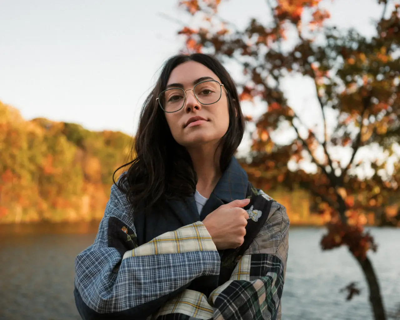 Woman wearing Article One glasses by lake in the fall