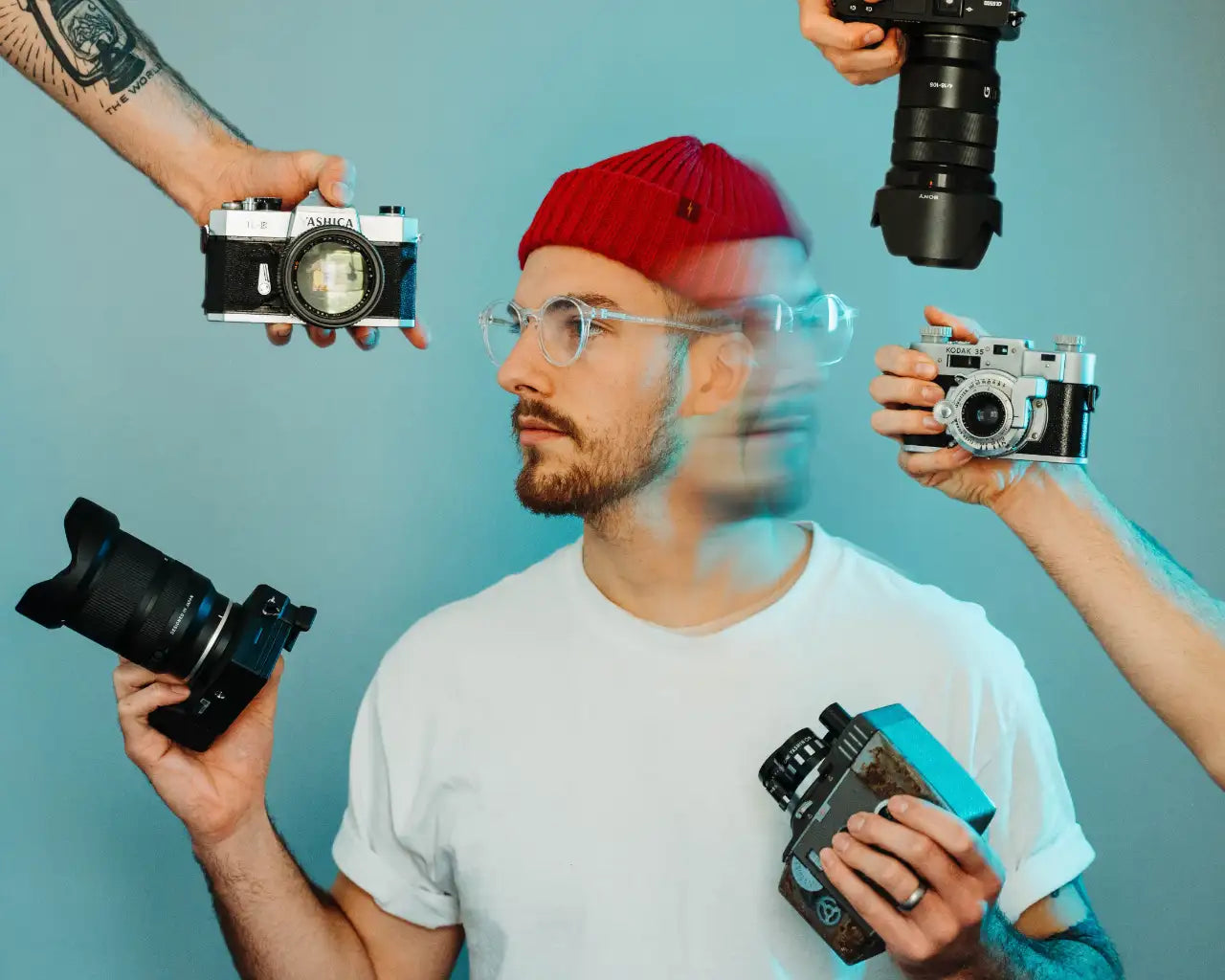 Man wearing clear plastic glasses looking at multiple cameras