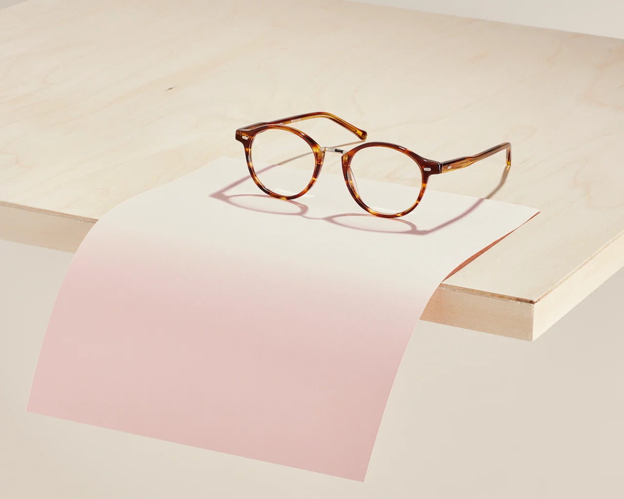 Round eyeglasses on table - image credit Article One