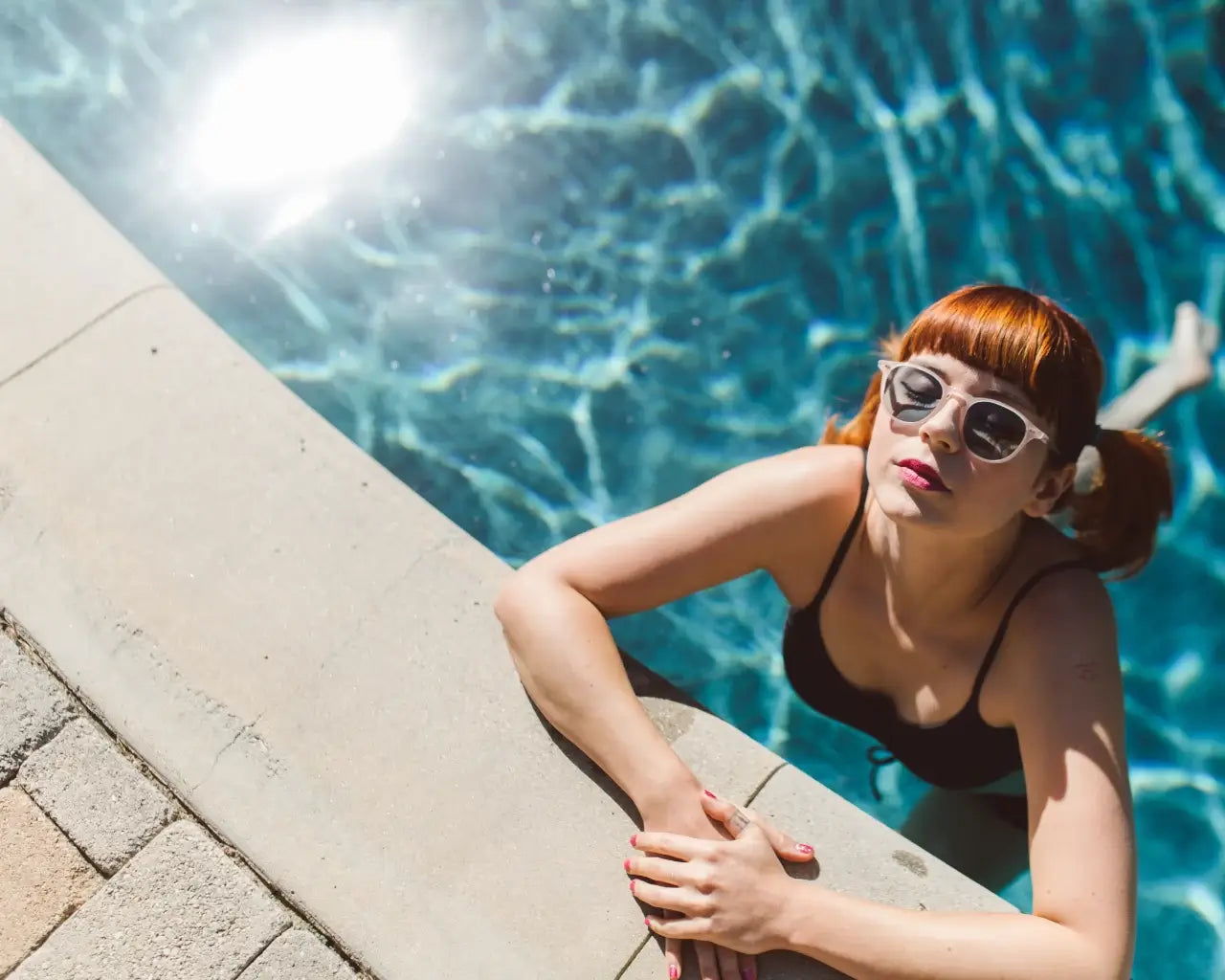 Woman in pool wearing Garrett Leight sunglasses