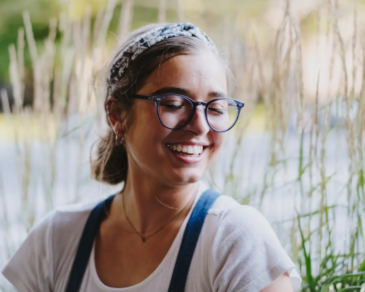 Woman by pond wearing blue round plastic eyeglasses from The Optical Co