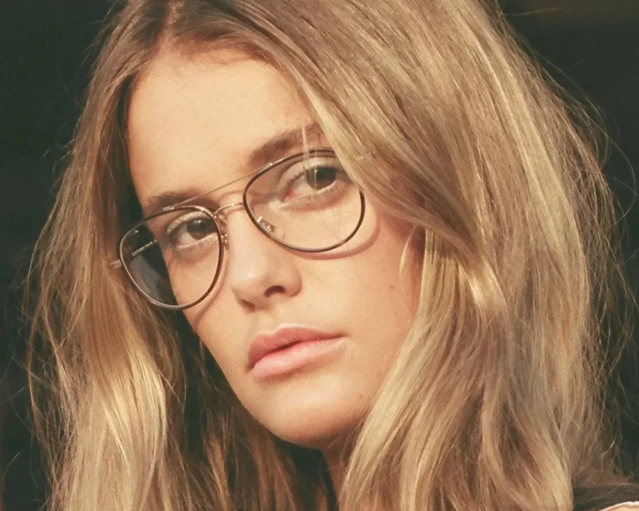 Model wearing Linnie metal eyeglass frames handmade in Japan by Garrett Leight