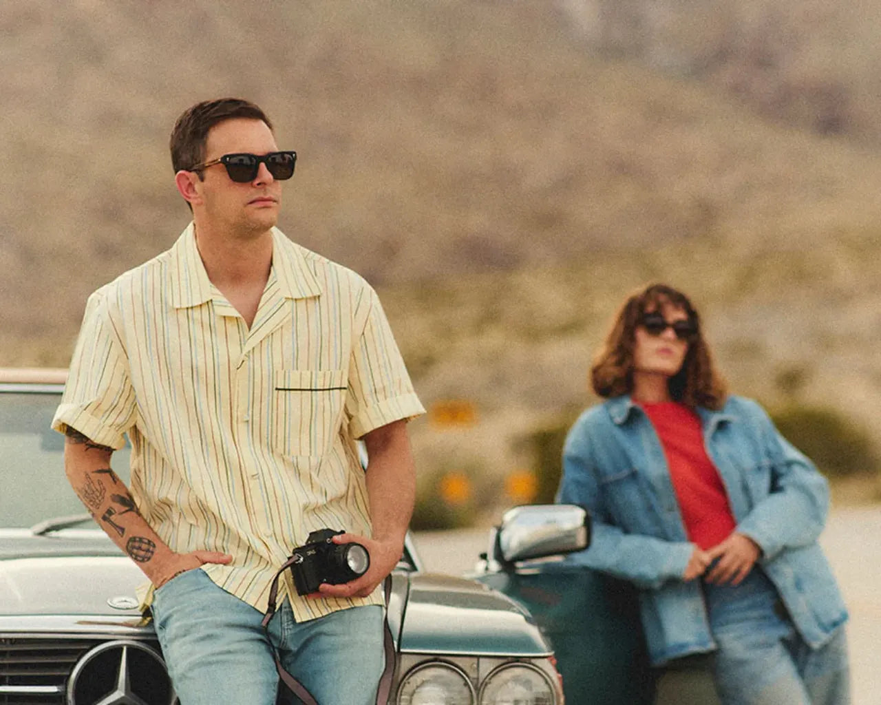 Couple wearing SALT eyewear holding a camera. Photo credit: SALT. 