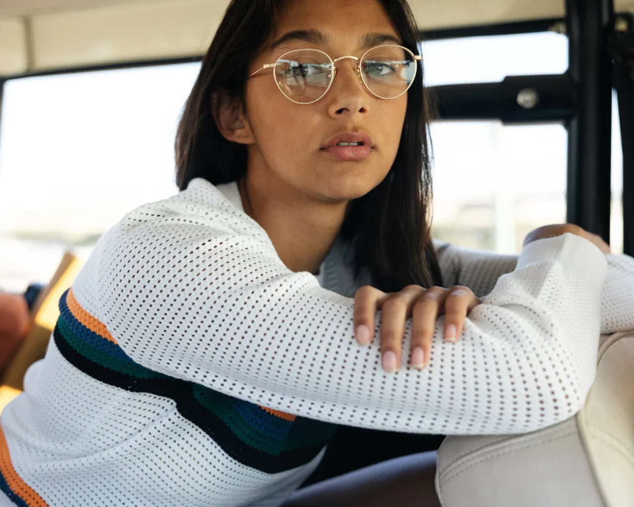 Model wearing round minimal metal eyeglass frames. Image credit: GLCO