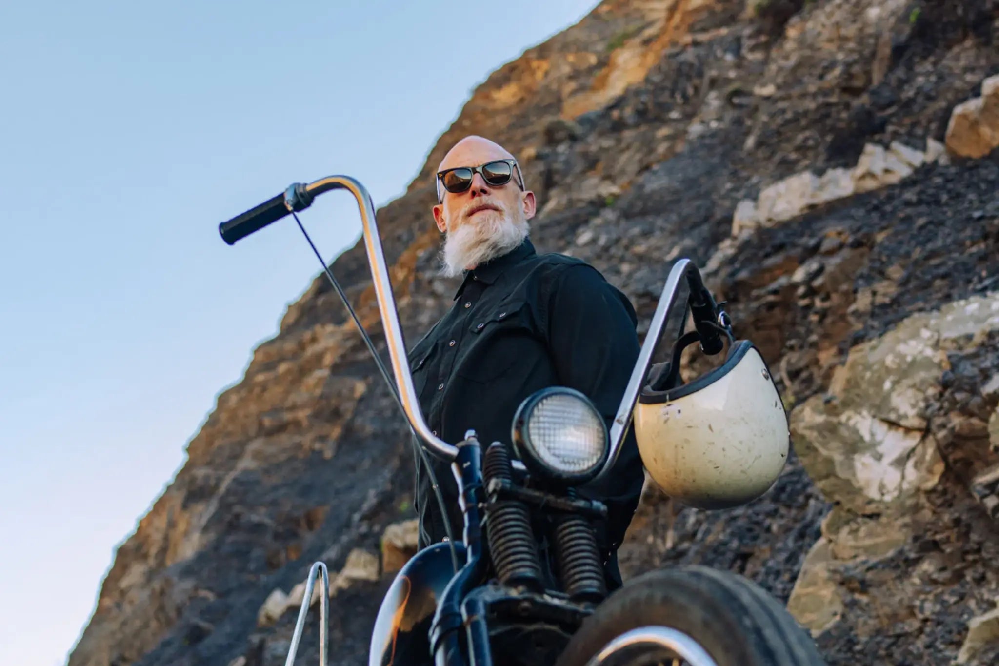 Man next to vintage motorcycle wearing sunglasses. Image by SALT. optics