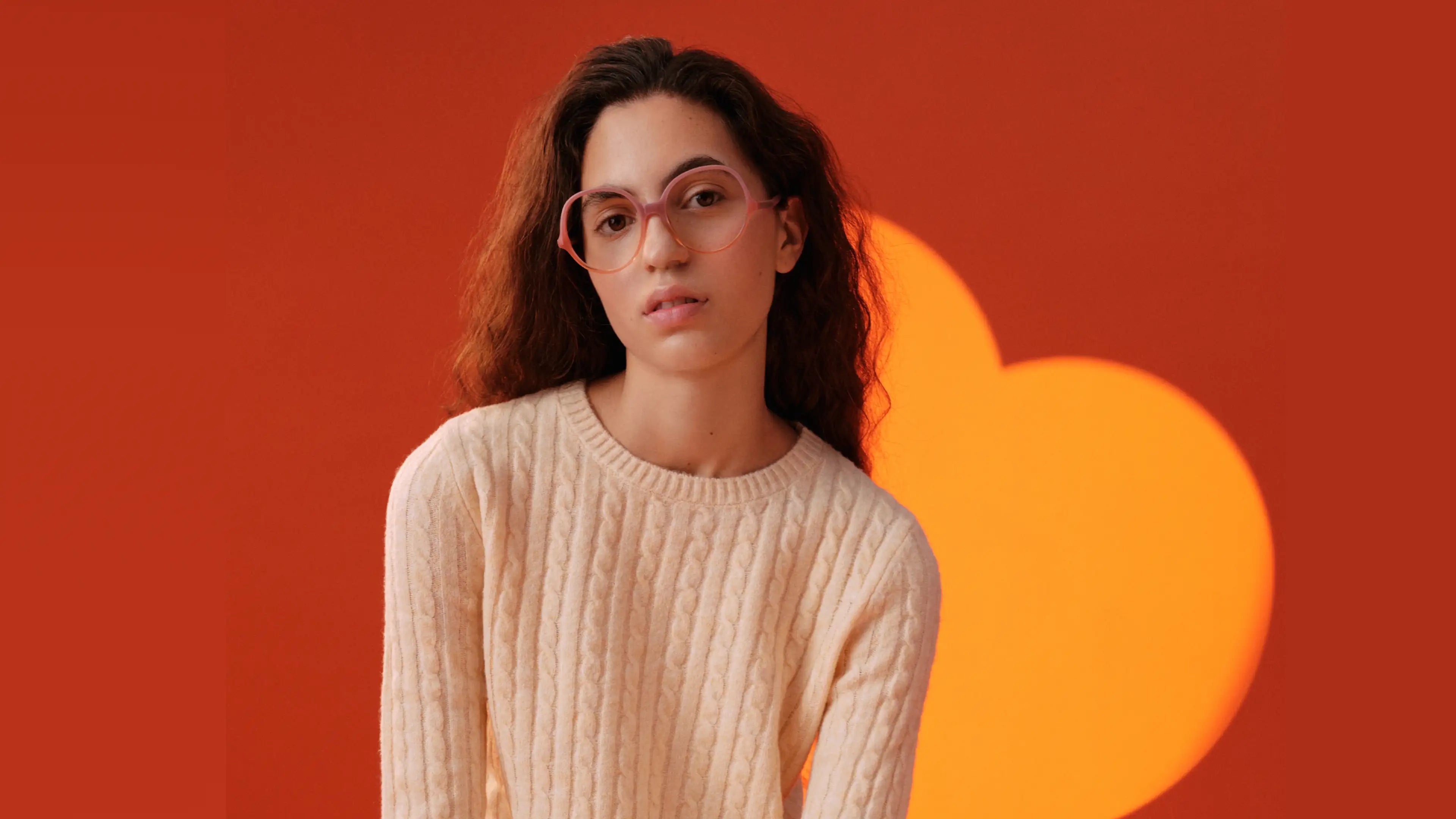 Model wearing Andy Wolf luxury eyeglass frames and white sweater