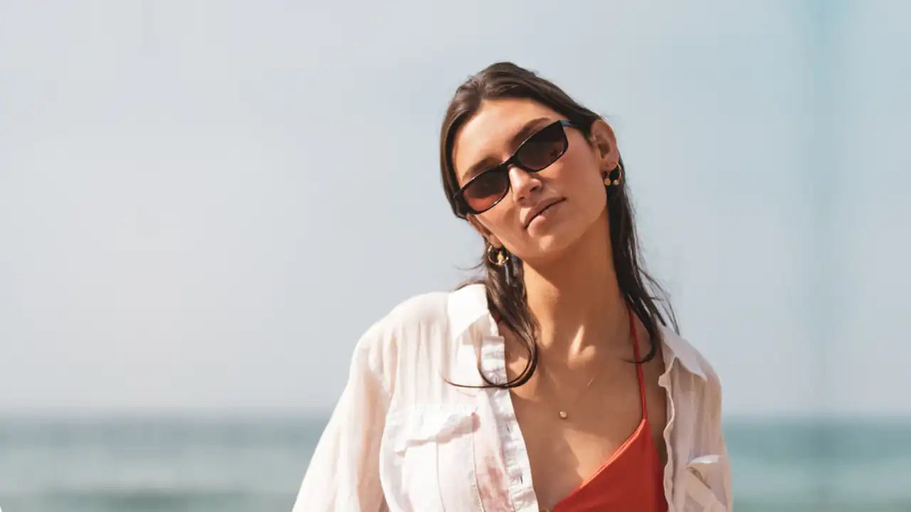 Model on beach wearing rectangular shaped luxury polarized sunglasses from SALT