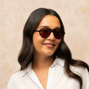 Model wearing black Garrett Leight plastic aviator sunglasses and white shirt