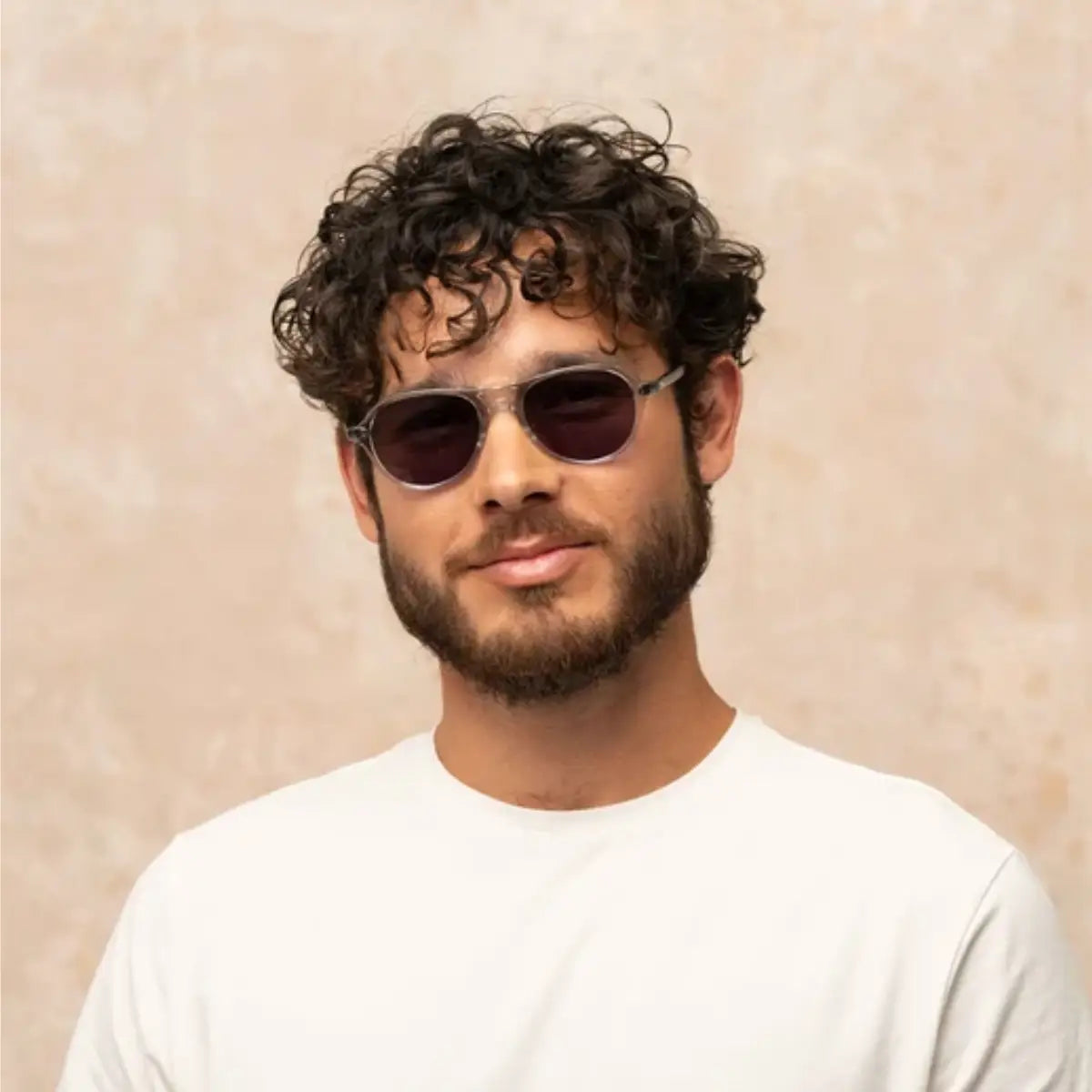 Model wearing clear LLG Garrett Leight plastic aviator sunglasses