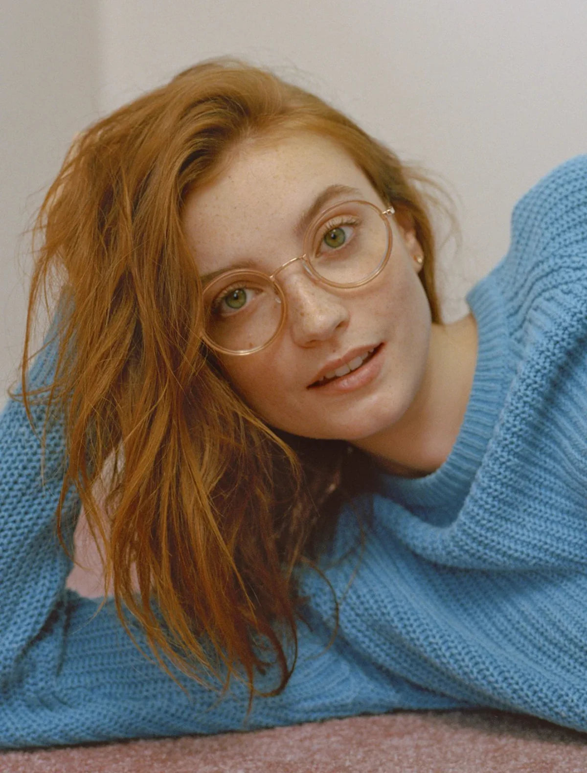 Person wearing Garrett Leight glasses and a blue sweater against a neutral background. Image credit: GLCO